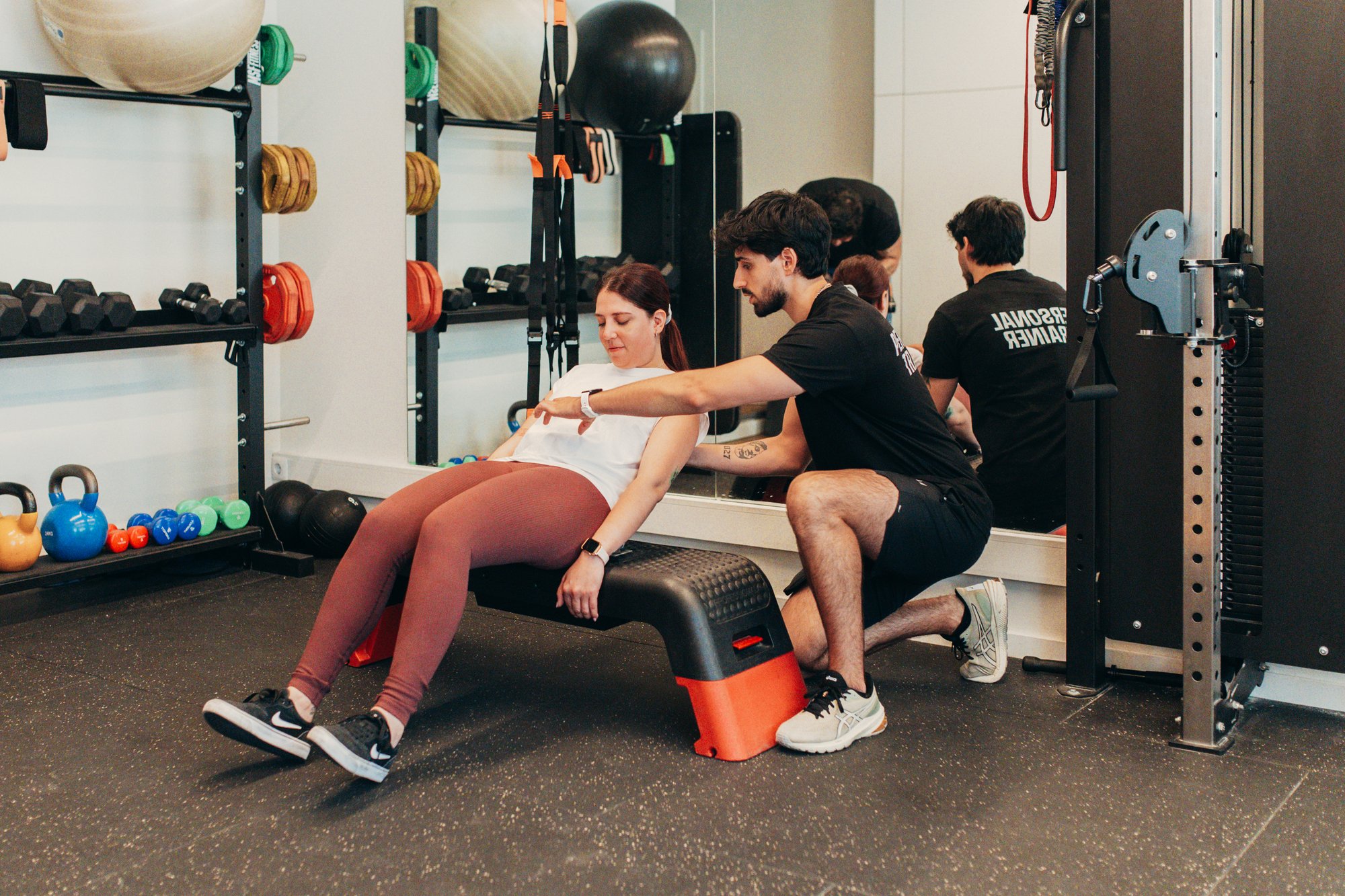 Personal Trainer a apoiar aluna num estúdio de treino personalizado em Lisboa