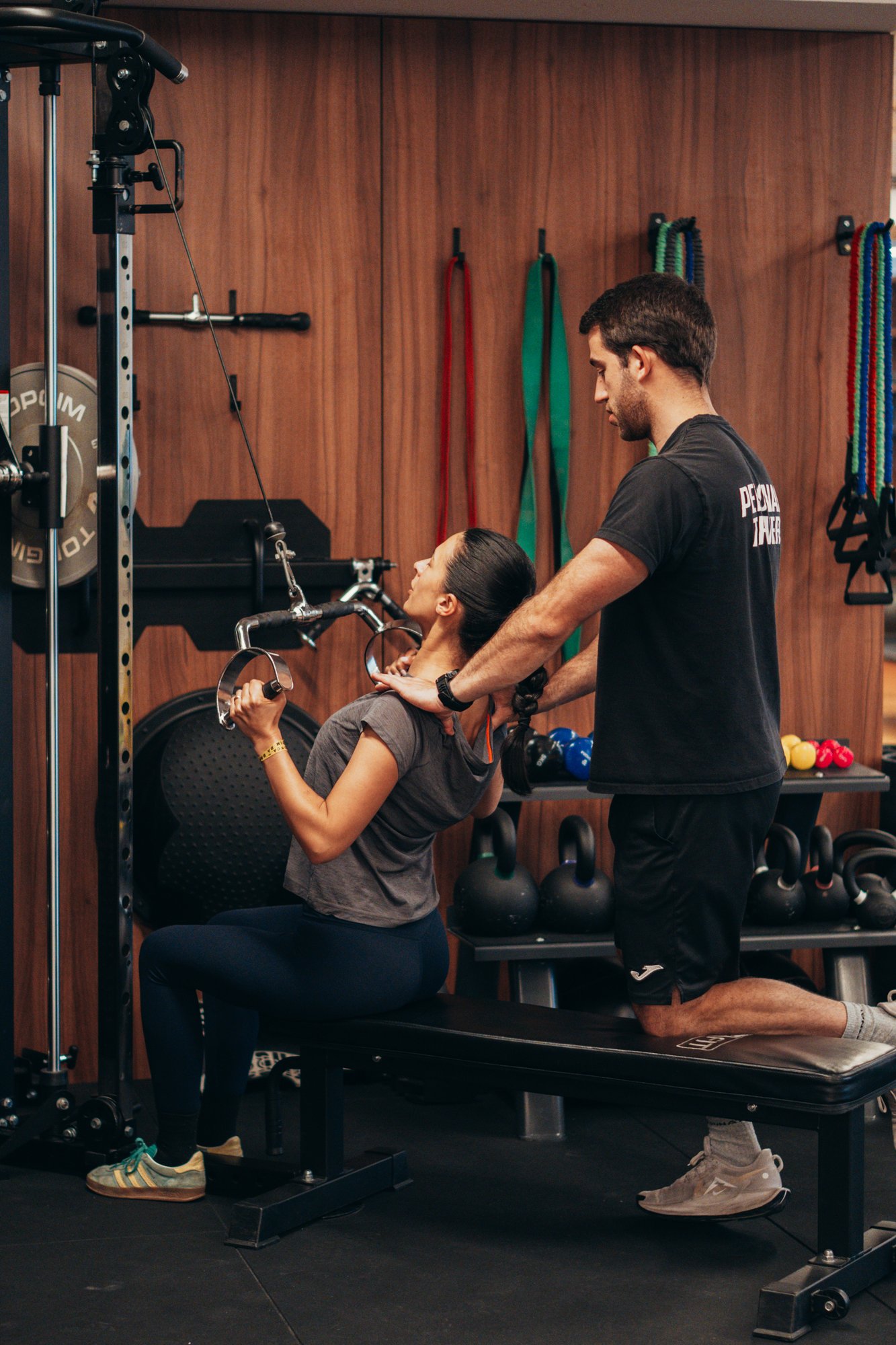 Personal Trainer a acompanhar treino com pesos livres num estúdio moderno em Lisboa