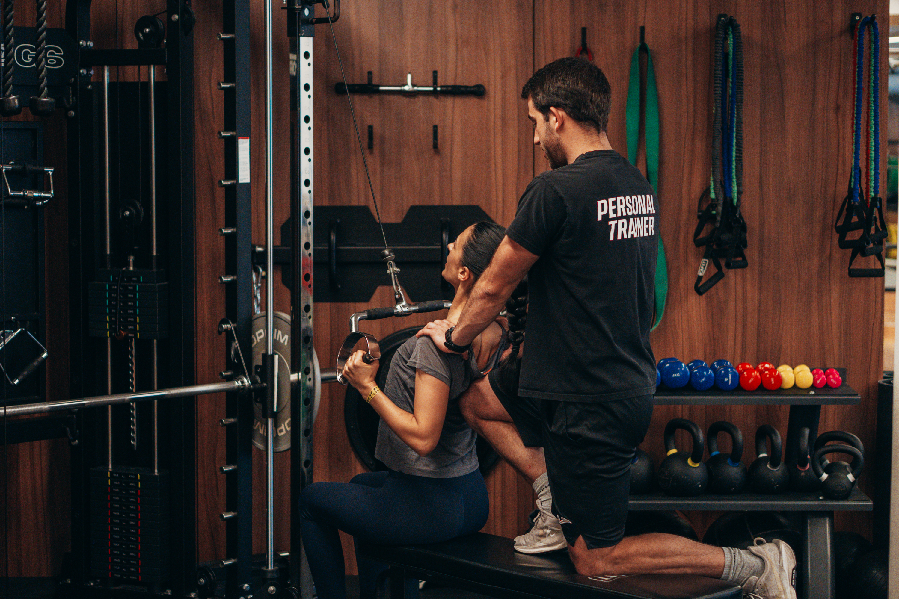 Personal Trainer a corrigir a postura e a acompanhar aluno num estúdio em Lisboa